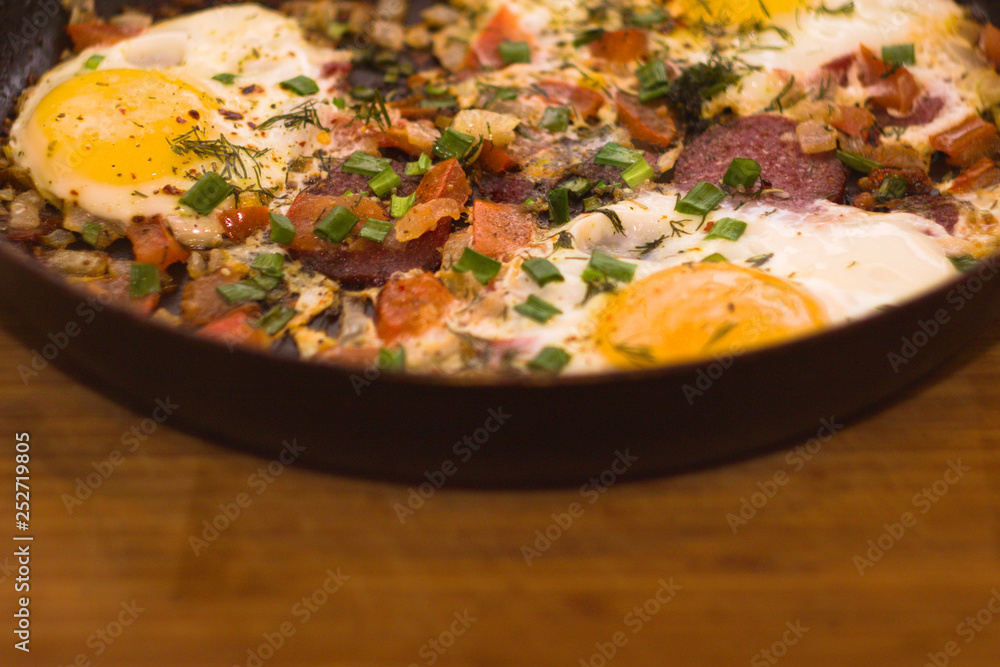 Scrambled eggs in a pan on a wood Board