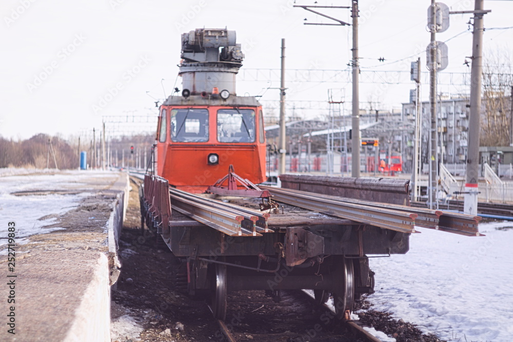 Railway crane stands on the tracks near the platform