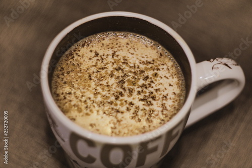 Coffee with chocolate, cinnamon and milk in a cup of white on a dark background