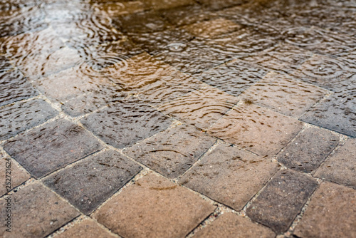фотографія Layer of water over patio pavers with light raindrops on the surface