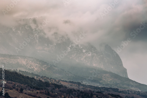 Fototapeta Naklejka Na Ścianę i Meble -  Low lying clouds on mountains in myst or dusk, dark dramatic and autumn depressive atmosphere