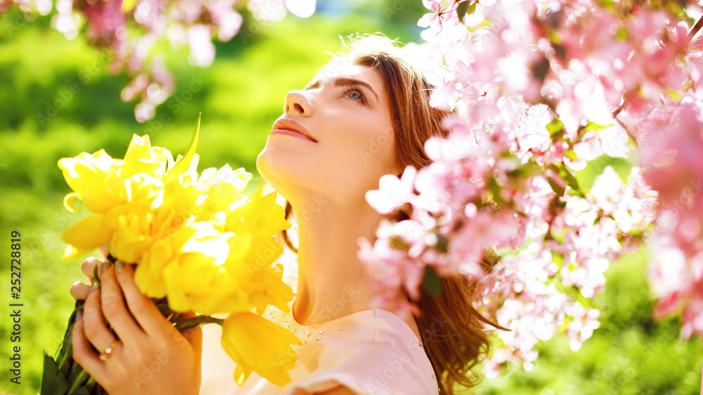 Beauty Portrait of Beautiful Young Brunette Woman In Nice Spring Dress With A Bouquet Of Tulips.Spring Style. Beautiful Spring Garden. Fashion Spring Summer Photo. Fashion and style concept. Long edge Beauty Portrait of Beautiful Young Brunette Woman In Nice Spring Dress With A Bouquet Of Tulips.Spring Style. Beautiful Spring Garden. Fashion Spring Summer Photo. Fashion and style concept. Long edge