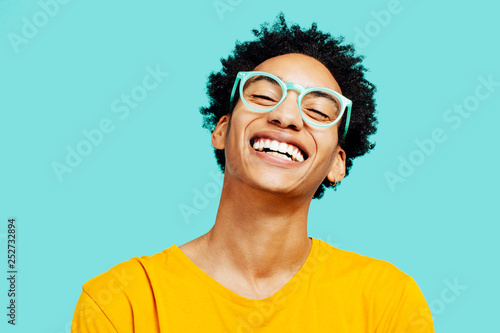 Portrait of a happy  young man isolated on blue background