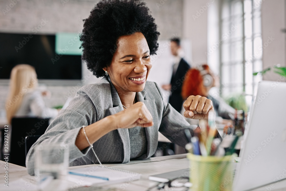 Happy black businesswoman working on laptop and celebrating her business achievement. Happy black businesswoman working on laptop and celebrating her business achievement.