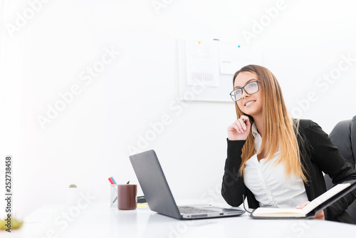 Attractive young woman in black cardigan working in the office.