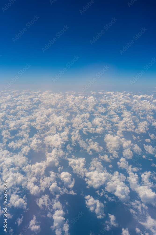 Fototapeta premium White clouds and blue sky, a view from airplane window