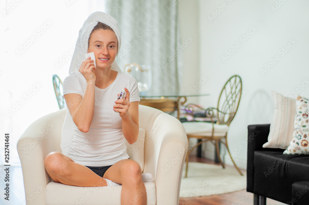 Beautiful woman removing makeup from her face at home Beautiful woman removing makeup from her face at home