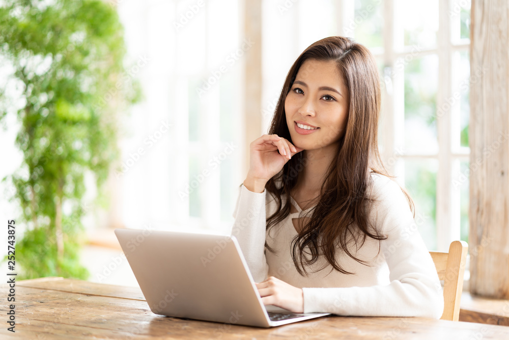 attractive asian woman using laptop in living room attractive asian woman using laptop in living room