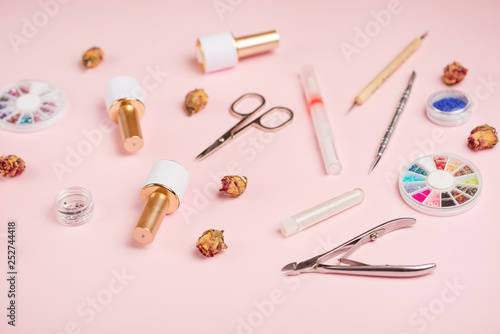 tool for manicure, gel polishes, scissors, tongs, accessories for working with pink nail on pink background. studio shot, service. Background