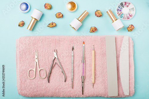 Manicure tools on a pink towel and a blue background. Manicure background. photo