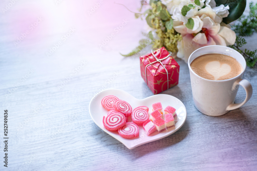 Sweet jelly in heart shaped plate for valentine's day with candle, silver star and a cup of latte coffee, gift box on wood background Sweet jelly in heart shaped plate for valentine's day with candle, silver star and a cup of latte coffee, gift box on wood background