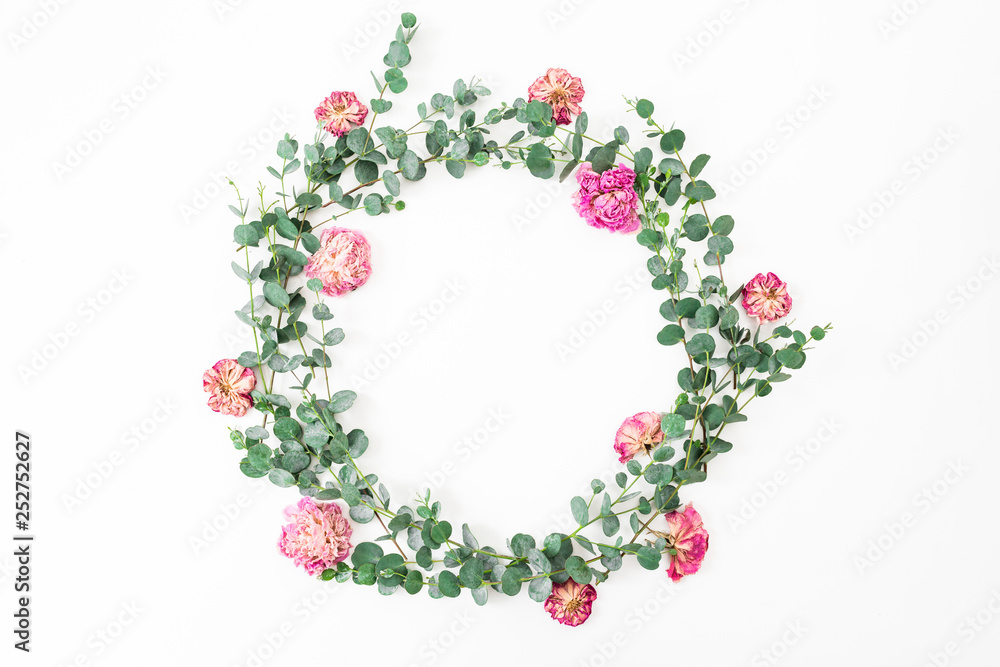 Floral frame with pink roses flowers and eucalyptus branch on white background. Flat lay, top view