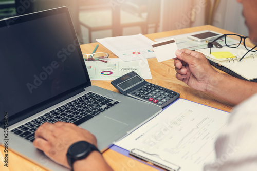 Businessman holding credit card and using laptop to shopping online