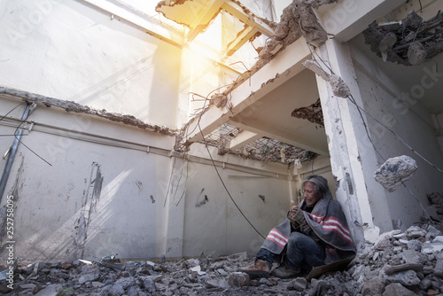 Man in an abandoned building destroyed, crying to lose his house destroyed by disaster or war