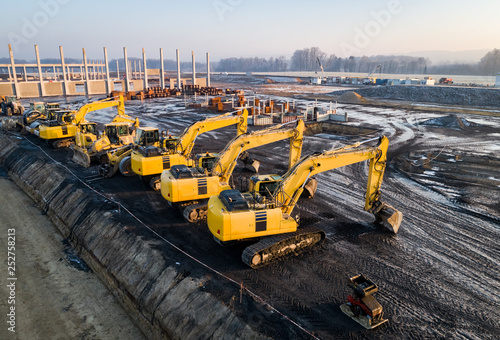 Grossbaustelle - Luftaufnahme - Bagger in einer Reihe aufgestellt photo