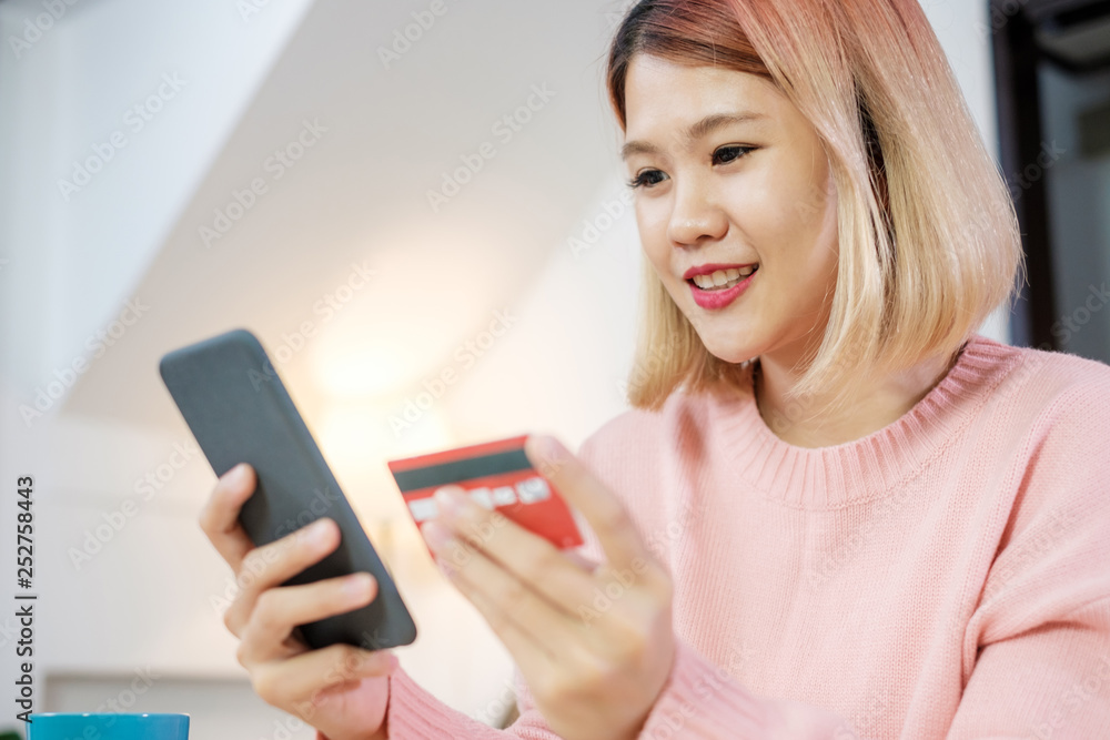 Asian woman online shopping with credit card and mobile phone at home.digital lifestyle with technology. Asian woman online shopping with credit card and mobile phone at home.digital lifestyle with technology.