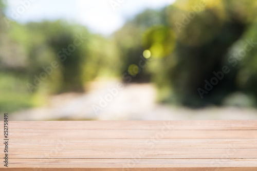 Wooden board empty table in front of blur Abstract natural green light.