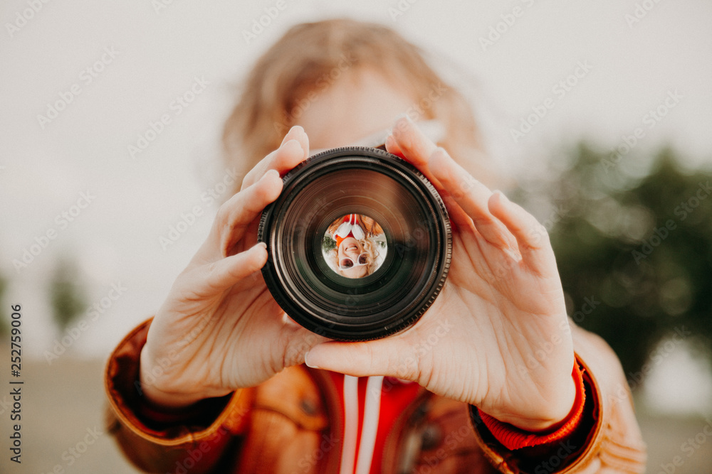 Young woman looking through camera lens. Photography and art concept. Stock  Photo | Adobe Stock
