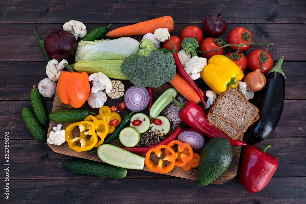 A mixture of vegetarian food for the Mediterranean diet. View from above. Photographed on a dark wooden background.