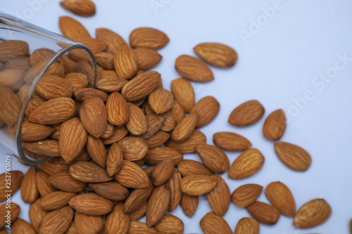 almonds on glass with white background, Indian almonds in white background, almonds were splatted out from the glass