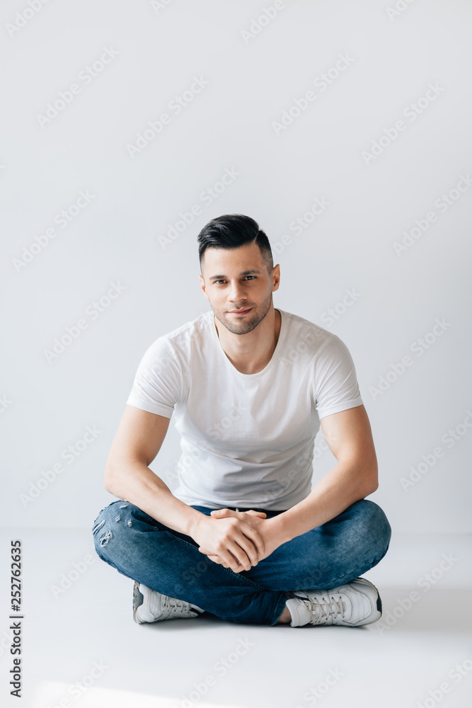 Handsome stylish man portrait sitting on floor Handsome stylish man portrait sitting on floor