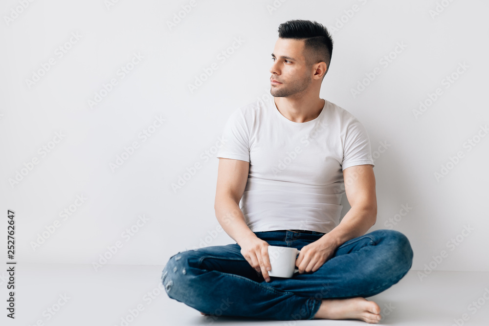 Handsome man with cup of coffee relax sitting on floor Handsome man with cup of coffee relax sitting on floor