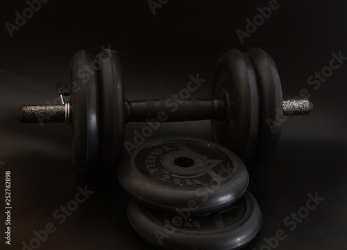 Dumbbell black, steel heavy weight, item for fitness, black background