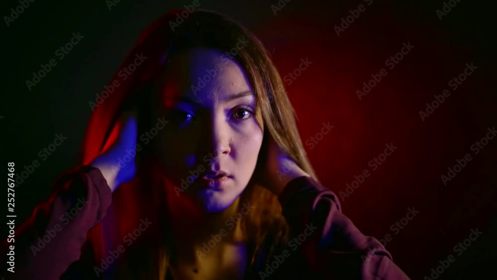 close-up portrait of a frightened woman in a dark room in neon light close-up portrait of a frightened woman in a dark room in neon light