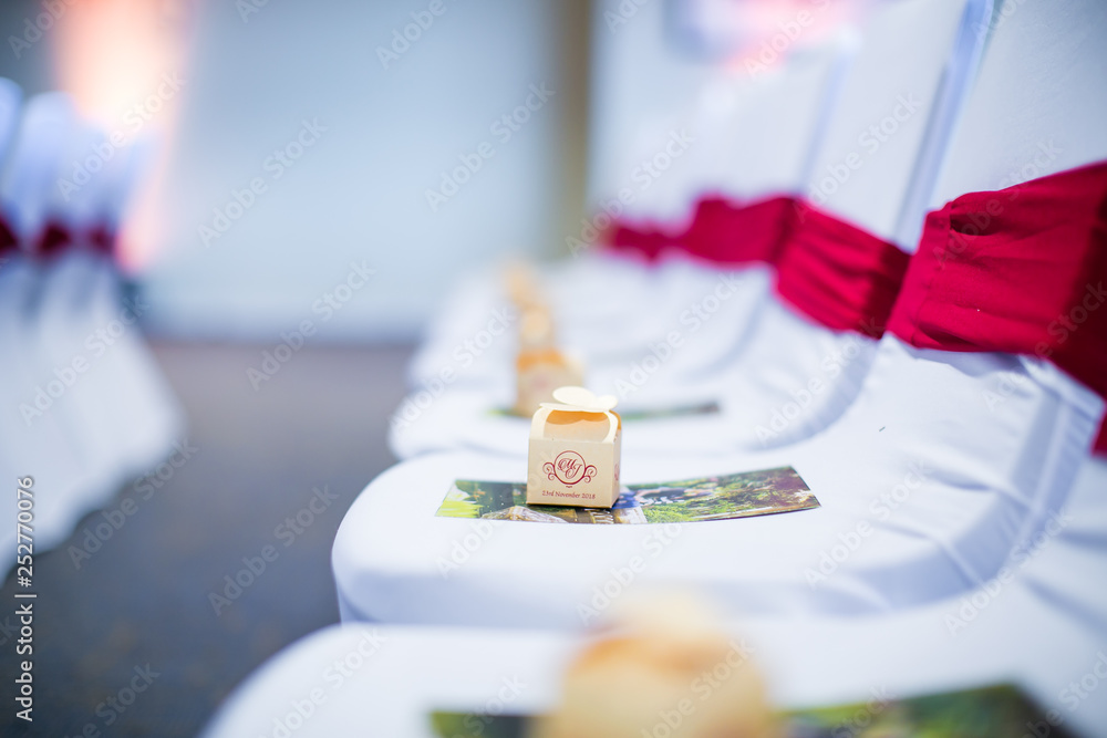 Wedding decorative chairs with red ribbons and gift boxes