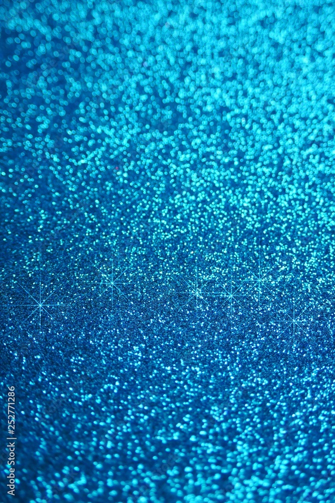 Fototapeta premium Glitter wallpaper. Glitter blue iridescent background with stars. Shiny backdrop.Snowy blue glitter shiny abstract Background.
