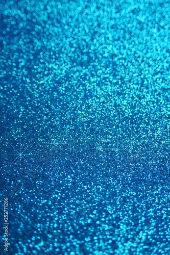 Glitter wallpaper. Glitter blue iridescent background with stars. Shiny backdrop.Snowy blue glitter shiny abstract Background.
