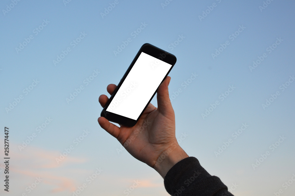Male hand holding smart phone at the sky background with clipping path