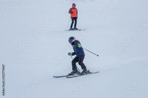 Two skiers skiing downhill in the Shymbulak ski resort in Kazakhstan