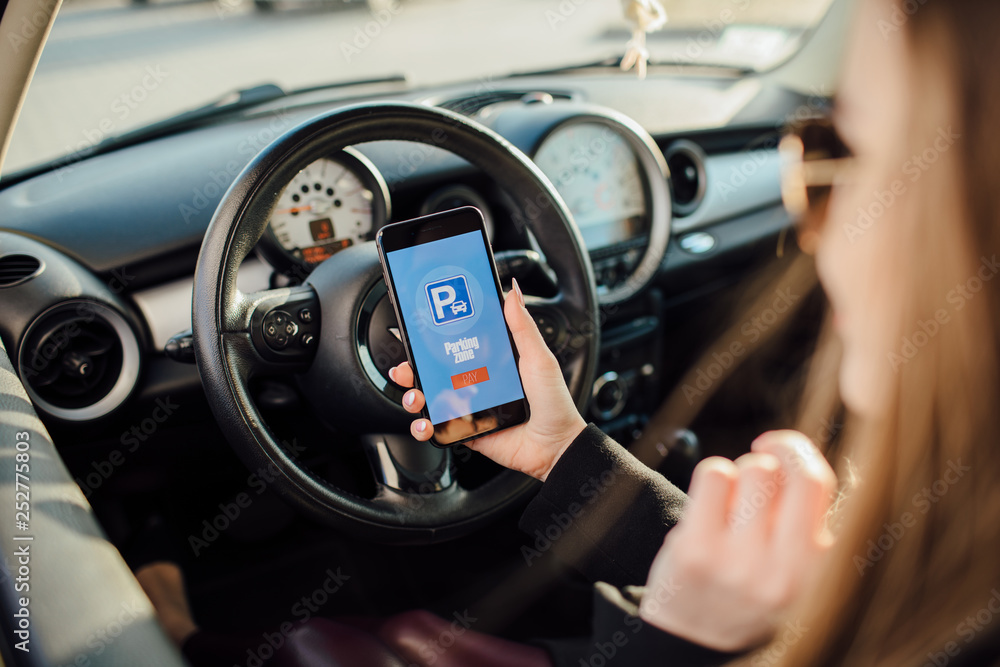 Obraz premium Girl using smartphone app to pay for the parking.