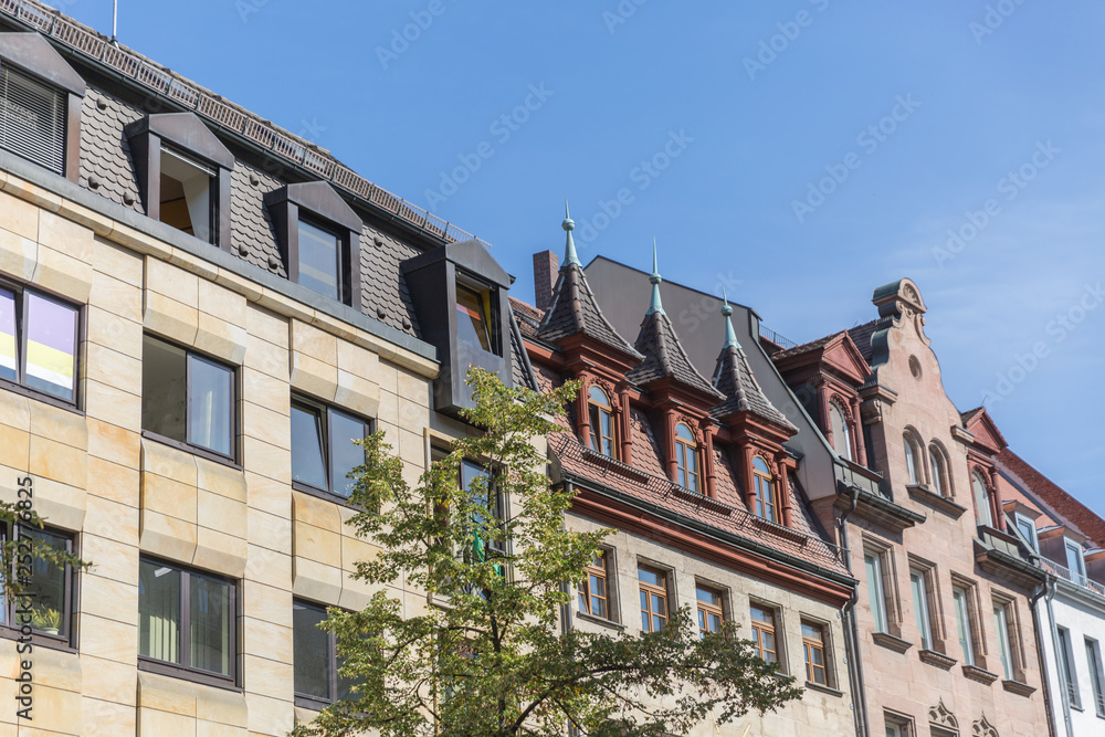 A row of beautiful unusual architecture style medieval houses with a tree before them Nuremberg