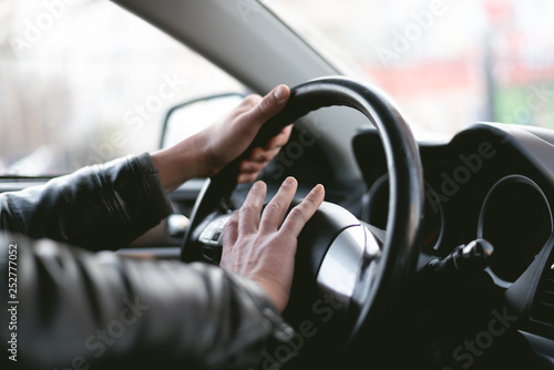 Angry driver is honking and is yelling by sitting of a steering wheel. Road aggression concept. Traffic jam.