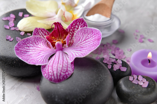 Spa stones and orchid flower on grey background  closeup