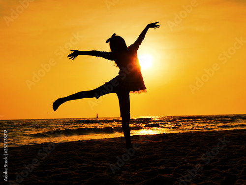 silhouette girl dancing ballet on the beach in sun rise.