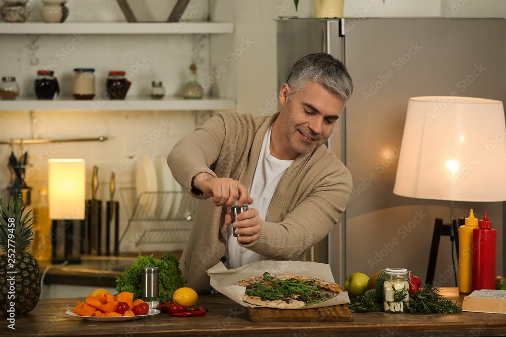 Mature man cooking tasty pizza at home Mature man cooking tasty pizza at home