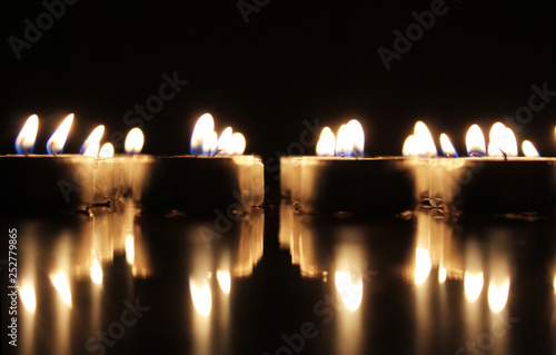 Burning candles on reflective surface