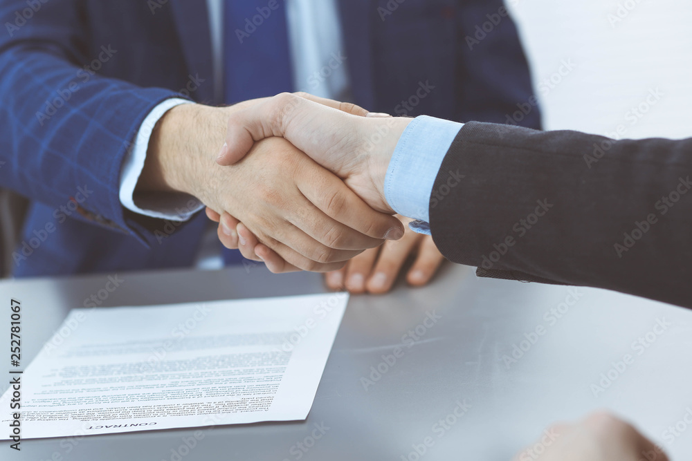 Business people shaking hands, finishing up a papers signing. Meeting, agreement and lawyer consulting concept