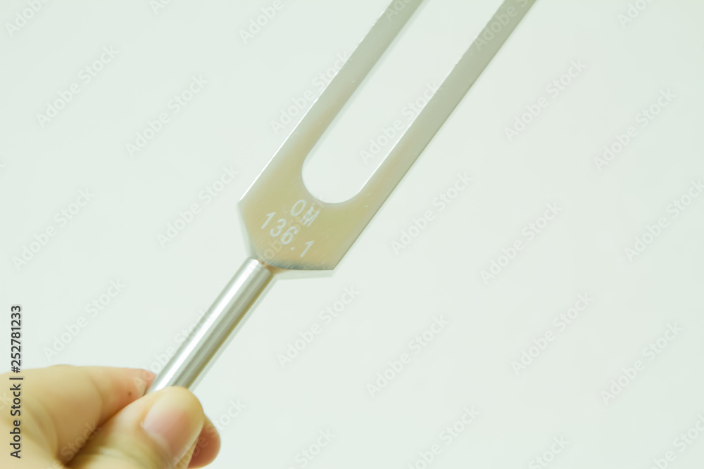 Hand holding a tuning fork . Hand holding a tuning fork .