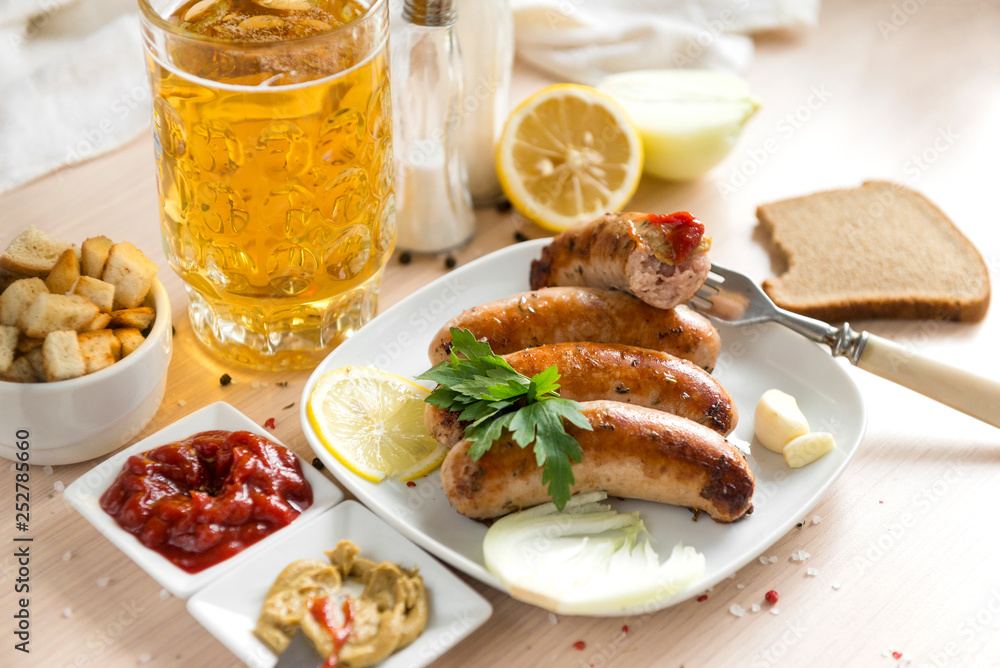 fried sausages on a plate, ketchup, mustard, spices, beer mug,