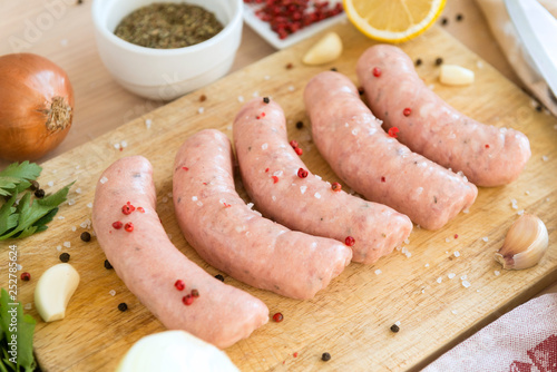 raw meat sausages with spices on the Board,