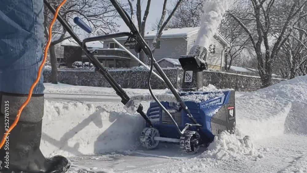 Close up and super slow motion of electric corded snowblower throwing