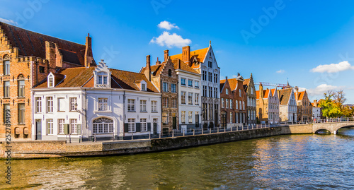 Bruges canal Spiegelrei with beautiful houses at sunset. Panoramic city view of traditional buildings and water canal. photo