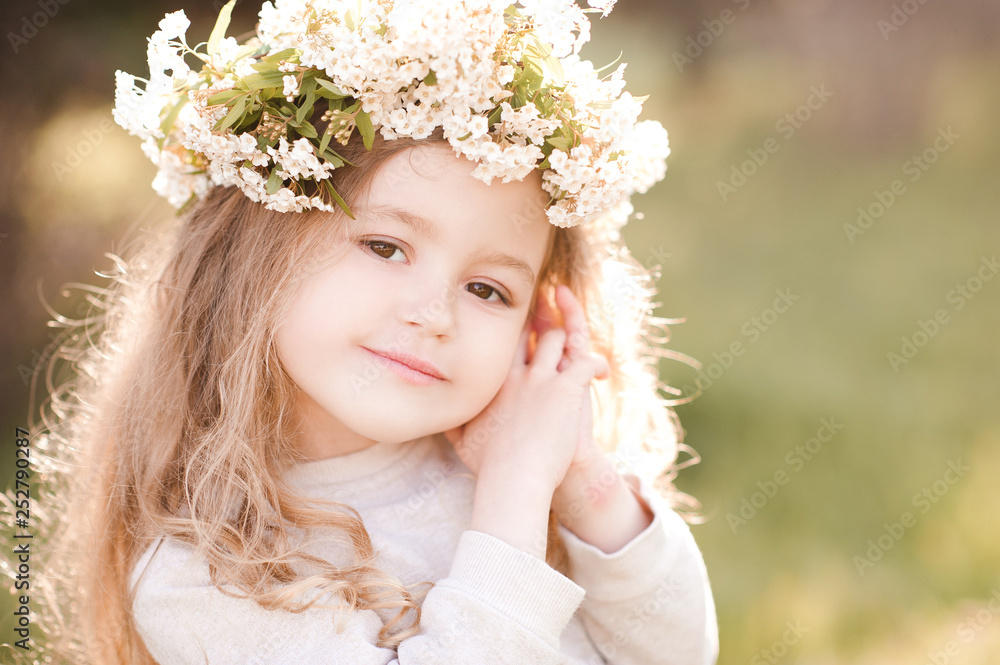 Cute baby girl 3-4 year old wearing floral wreath outdoors. Looking at camera. Spring season. Cute baby girl 3-4 year old wearing floral wreath outdoors. Looking at camera. Spring season.