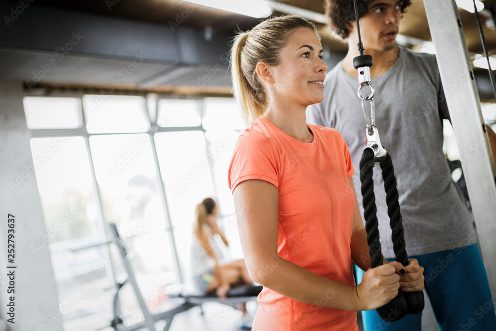 Personal trainer helping young woman reach goals Personal trainer helping young woman reach goals