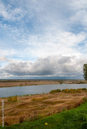 Rural landscape near the Konstantinovo village with clouded skies and meadows and hills