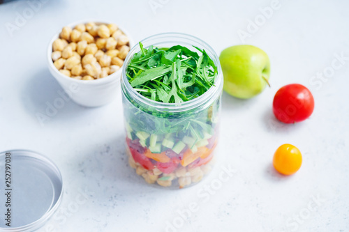 Healthy salad with chickpeas and arugula in a jar. Take away easy lunch concept